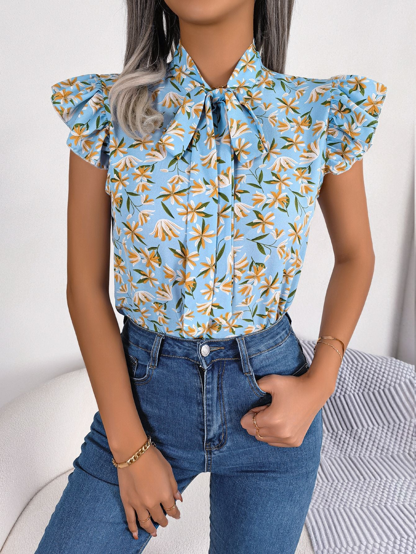Blusa con mangas abullonadas y cuello con lazo floral