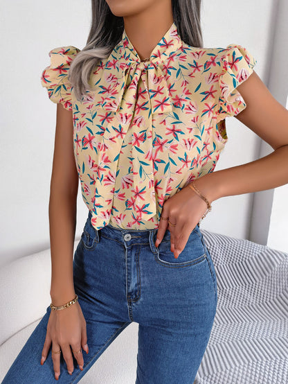 Blusa con mangas abullonadas y cuello con lazo floral