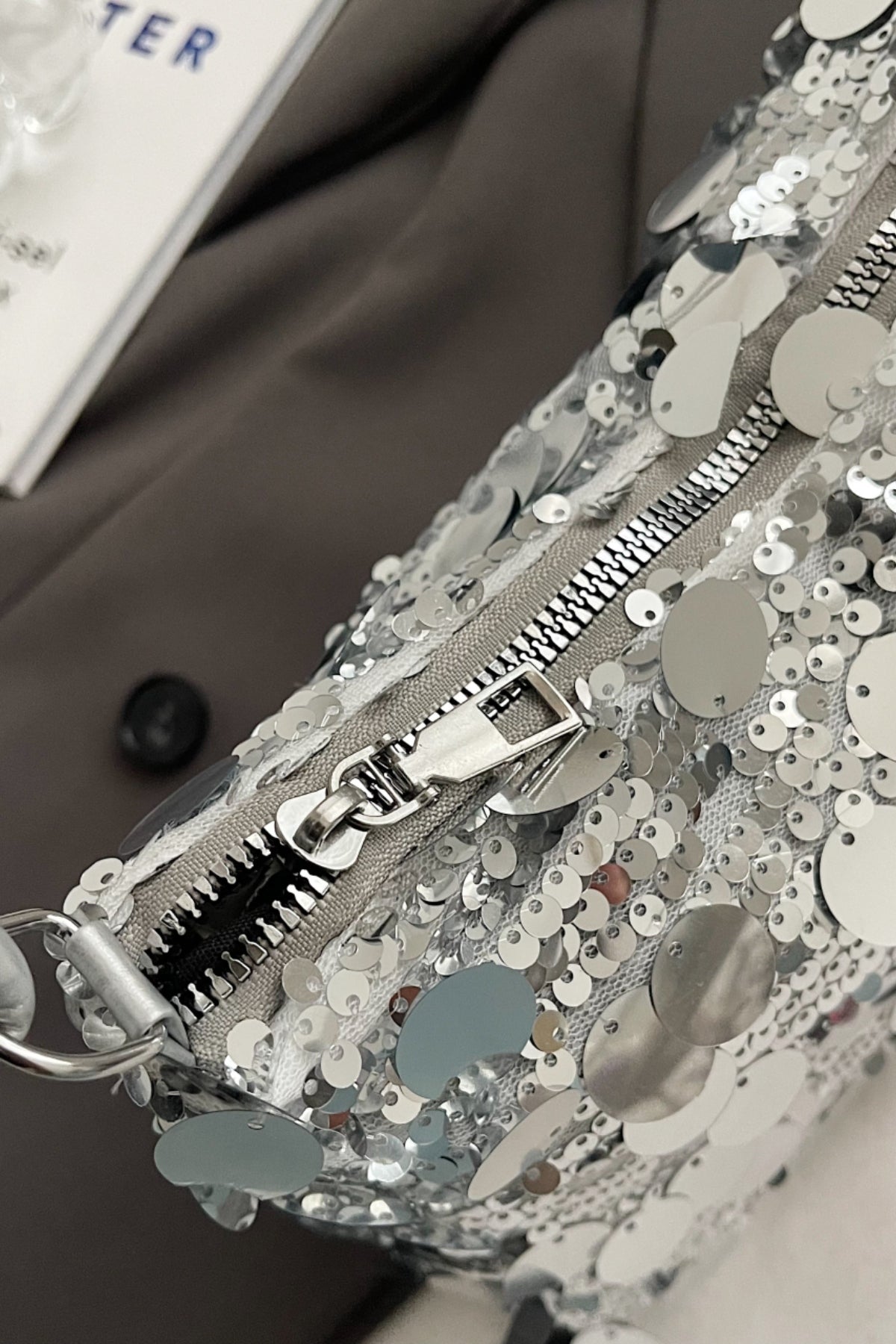 Schultertasche mit Pailletten und geknoteten Riemen