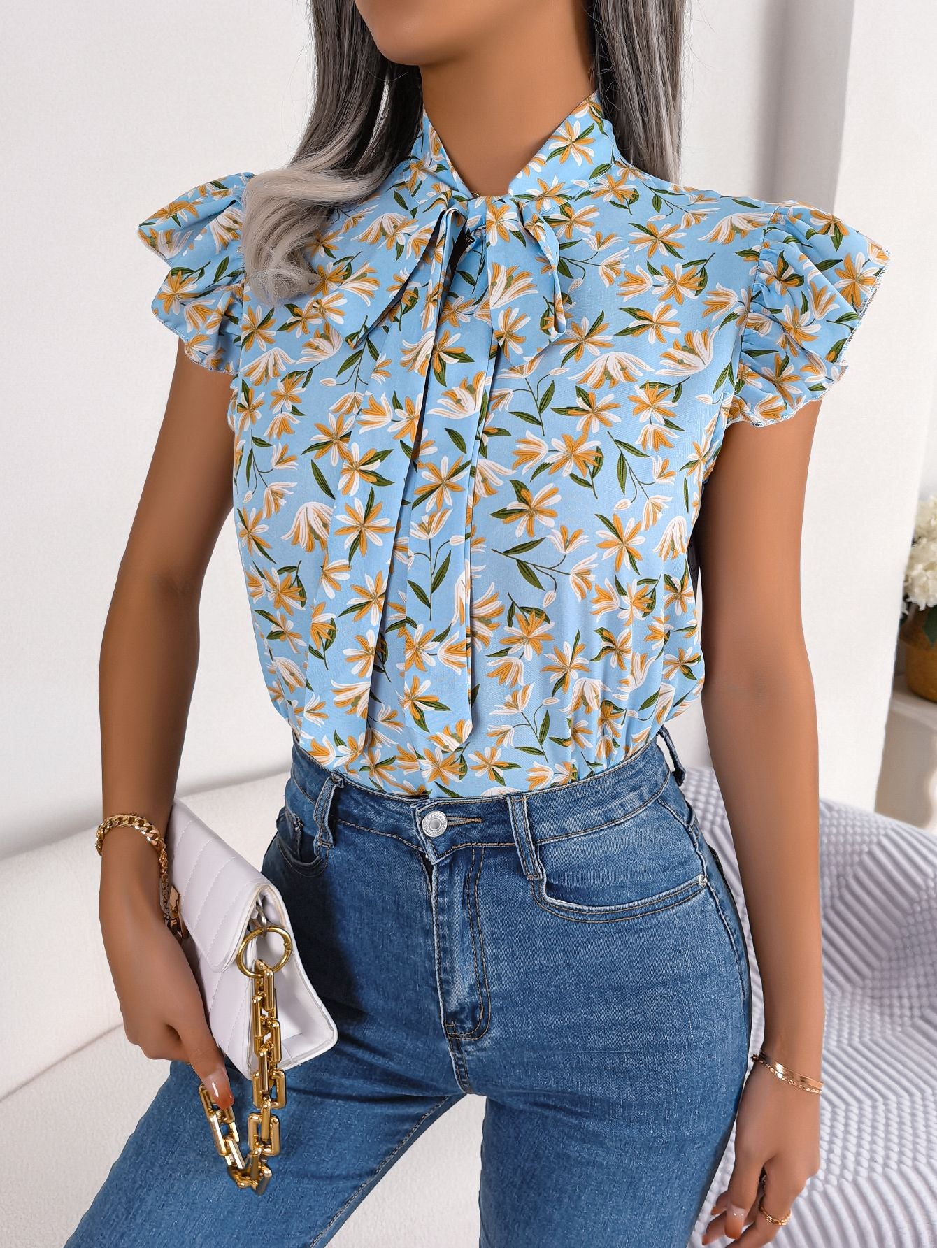 Blusa con mangas abullonadas y cuello con lazo floral