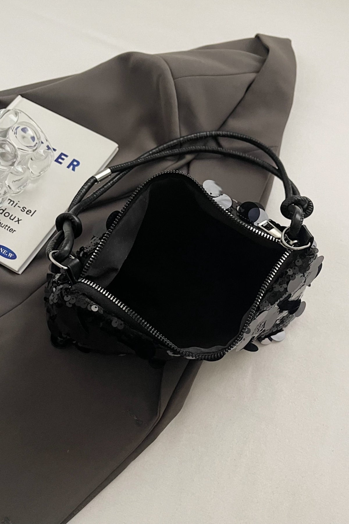 Schultertasche mit Pailletten und geknoteten Riemen